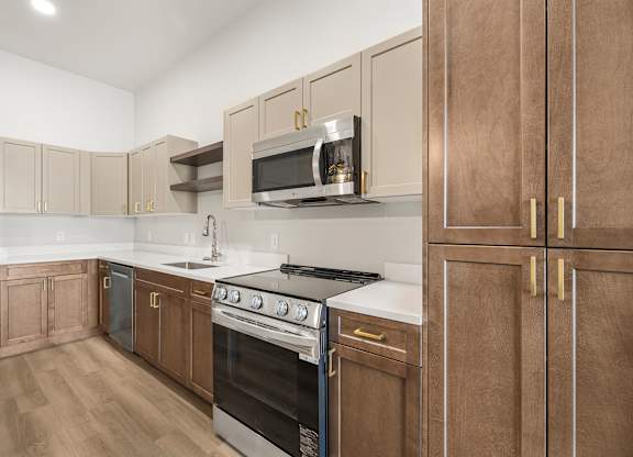 A kitchen with wooden cabinets and a stainless steel refrigerator.