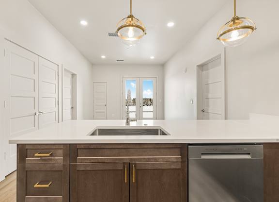 A modern kitchen with a large island and stainless steel appliances.