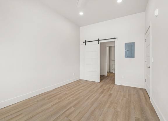 A room with a sliding door and wood flooring.
