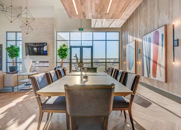 A modern dining room with a long table and chairs.