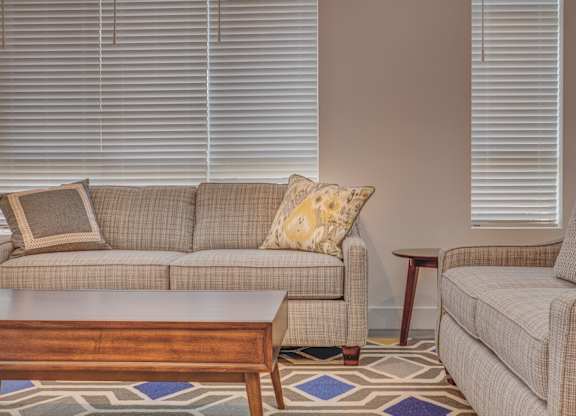 A living room with a couch, chair, and coffee table.