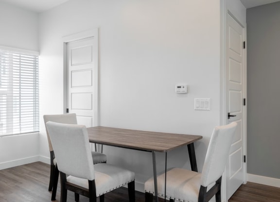 a dining room with a wooden table and white chairs