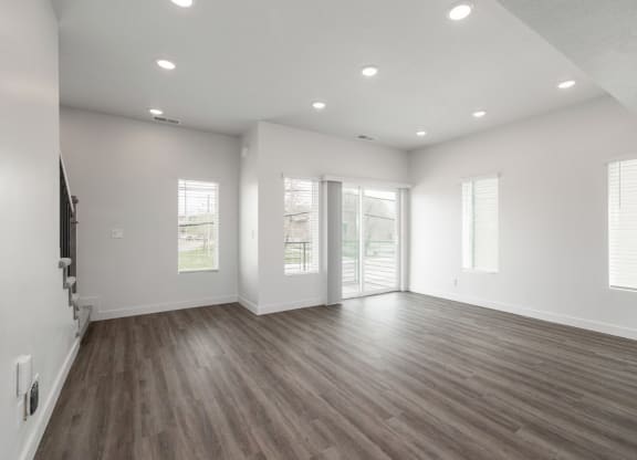 an empty living room with white walls and wood floors