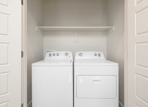 a washer and dryer in a laundry room with white doors