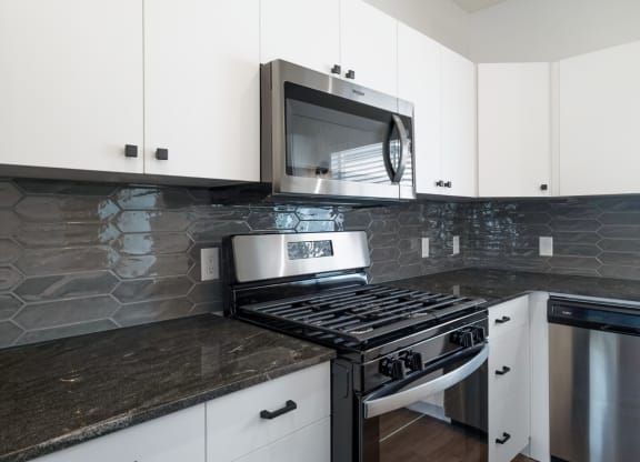 a kitchen with white cabinets and a stove and a microwave