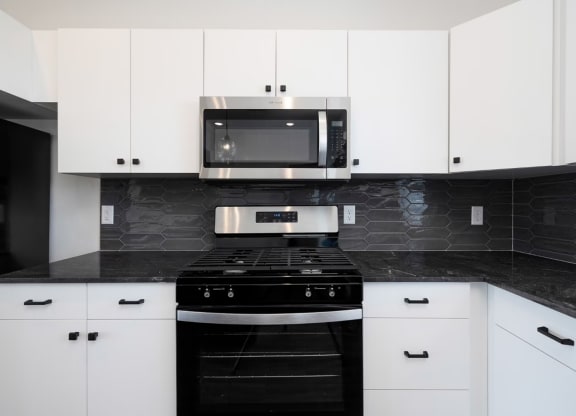 a black and white kitchen with a stove and a microwave