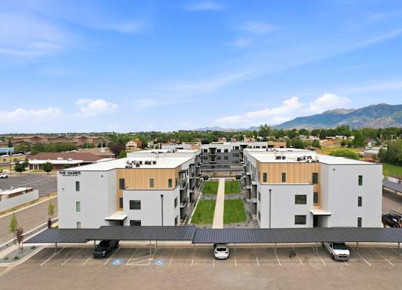 A parking lot in front of a building with a mountain in the background.