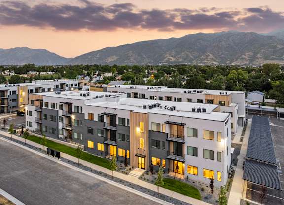 A modern apartment complex with a mountain range in the background.