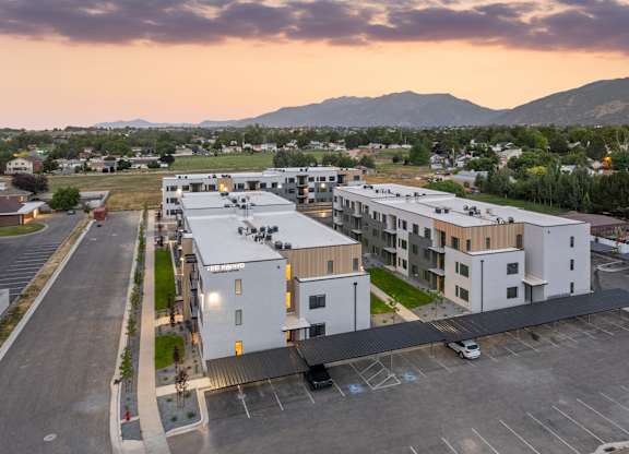 A parking lot in front of a building with a mountain in the background.