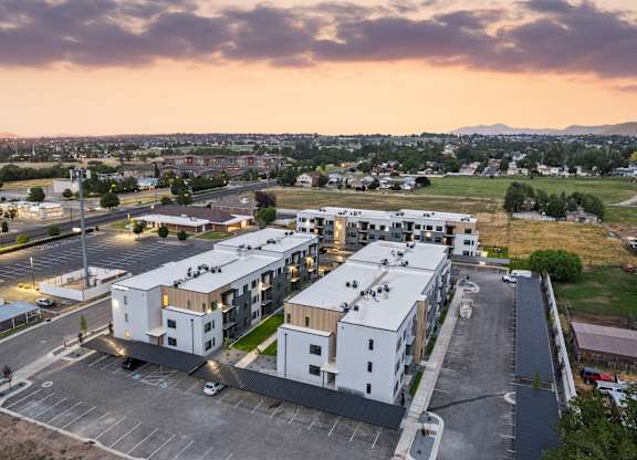 A parking lot with a building in the background during sunset.