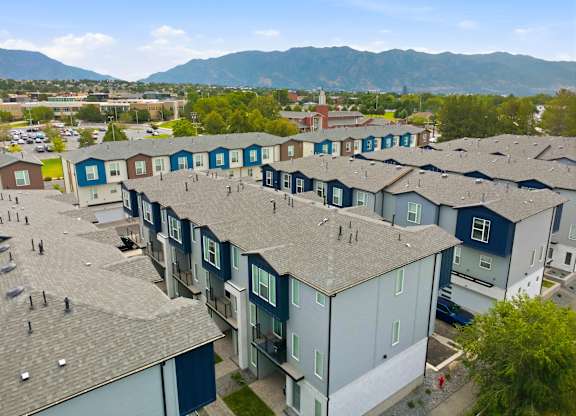 Apartment complex with grey roofs and blue doors.