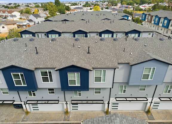 A row of houses with grey roofs and blue and white walls.
