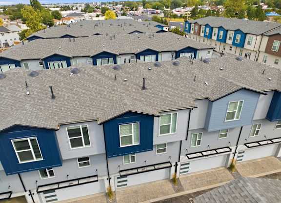 A large group of houses with grey roofs and blue trim.