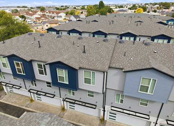 A row of houses with grey roofs and blue trim.