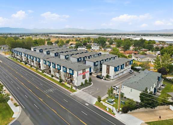 A road with a building on the side and mountains in the distance.
