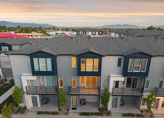 A modern apartment complex with balconies and a mountain range in the background.