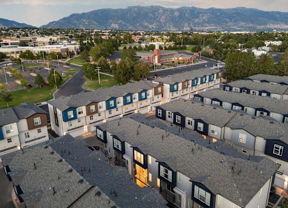 A large housing complex with a mountain range in the background.