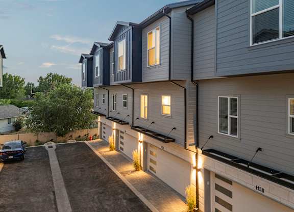 A modern apartment building with a car parked in the driveway.