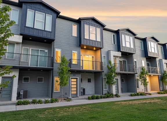 A row of modern townhouses with balconies and doors.