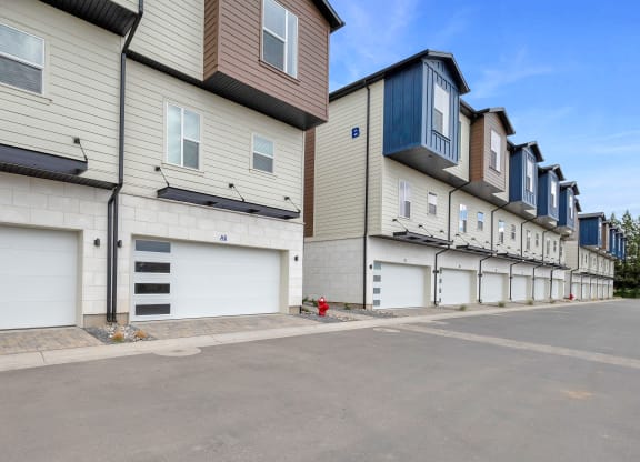 a row of houses with white garage doors and a red fire hydrant