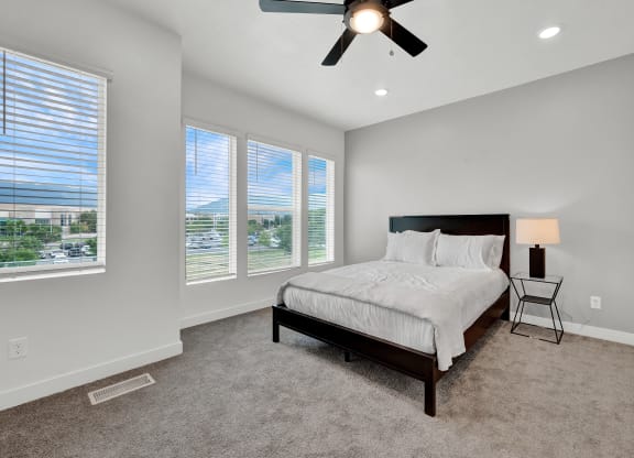 an empty bedroom with a bed and a ceiling fan