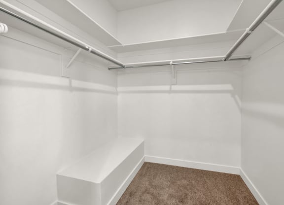 a empty white room with white walls and a brown carpet