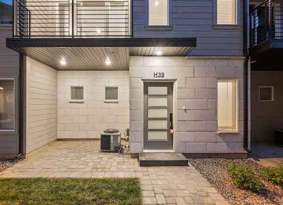 A house numbered H39 with a grey door and a small garden.