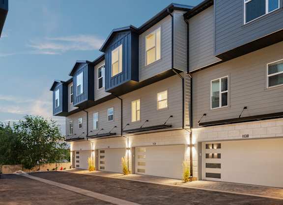 A modern apartment building with garages on the ground floor.