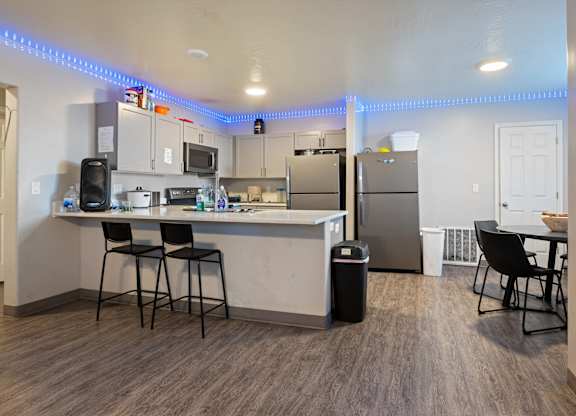 A kitchen with a bar area and a refrigerator.