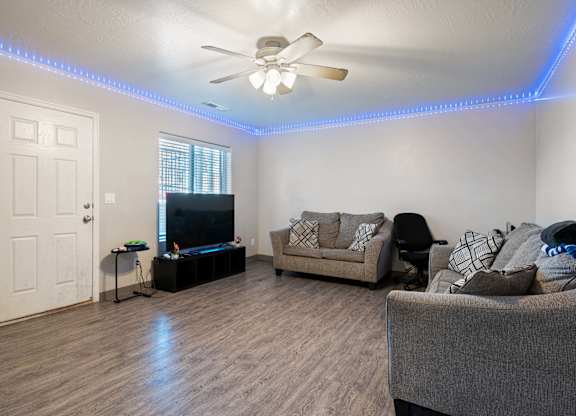 A living room with a couch, chair, and television.