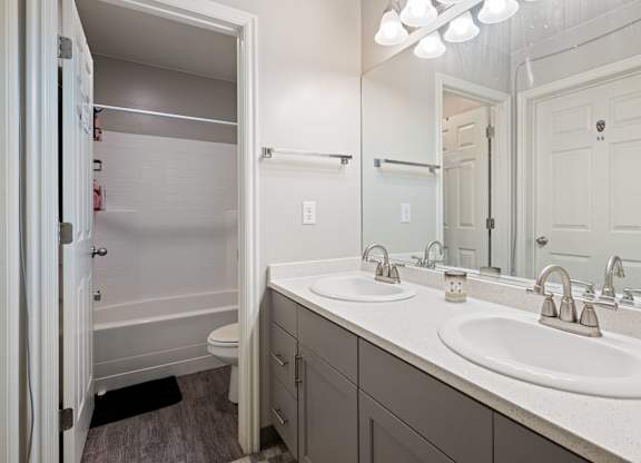 A bathroom with a white sink and a white toilet.
