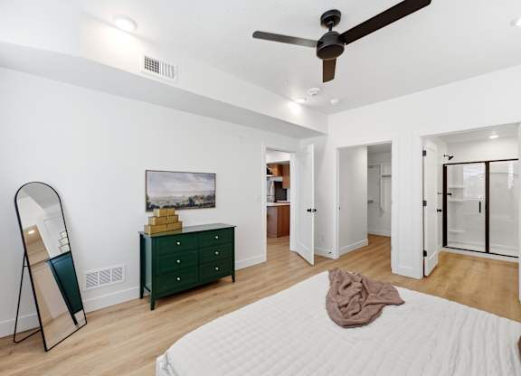 A bedroom with a white bed and a green dresser.
