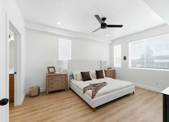 A bedroom with a large bed and a ceiling fan.