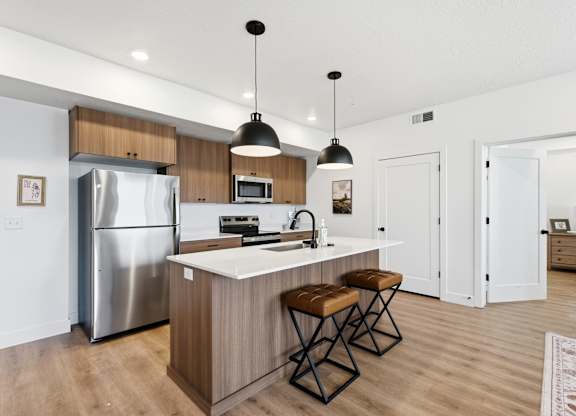 A modern kitchen with a wooden island and stainless steel appliances.
