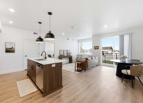 A modern kitchen with a large island and pendant lights.