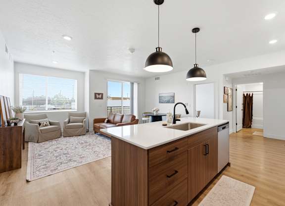 A modern kitchen with a large island and pendant lights.