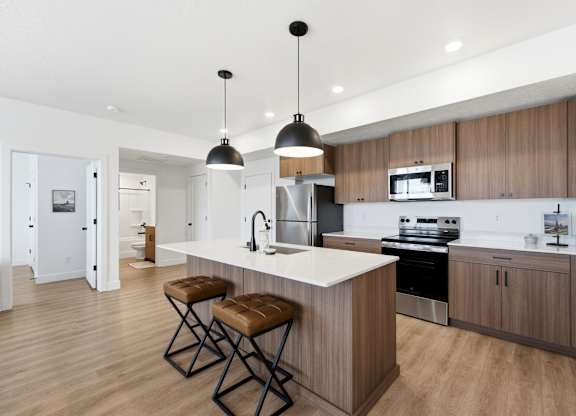 A modern kitchen with a white countertop and wooden cabinets.