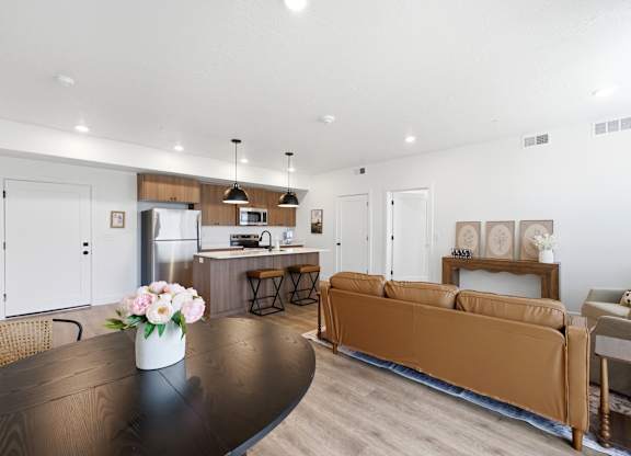 A modern living room with a brown couch and a black table.