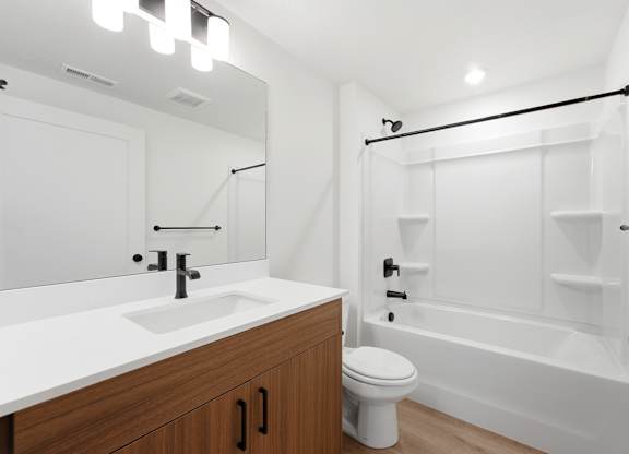 A white bathroom with a sink, toilet, and bathtub.
