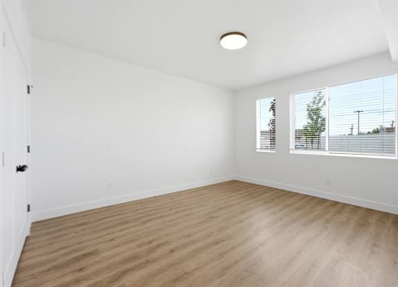 A room with wooden flooring and white walls.