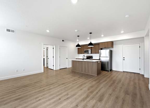 A kitchen with a refrigerator, microwave, and oven.
