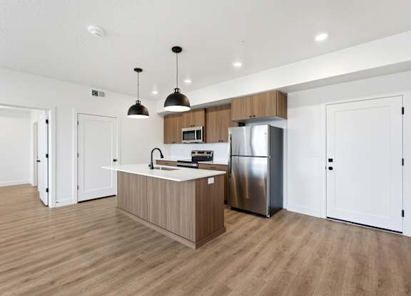 A kitchen with a wooden island and stainless steel appliances.