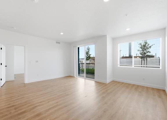 A large empty room with wooden floors and white walls.
