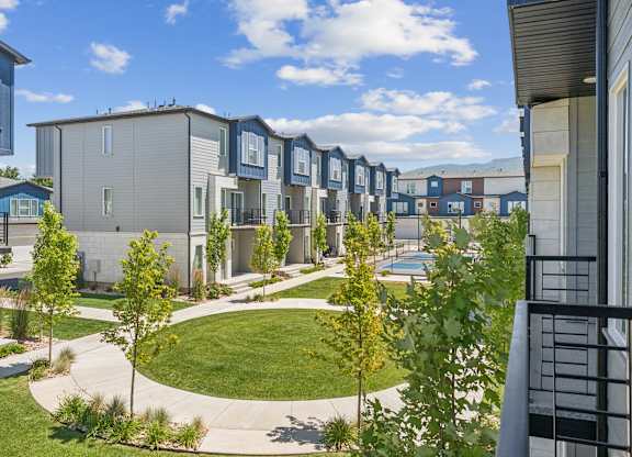 A row of modern townhouses with a small grassy area in the middle.