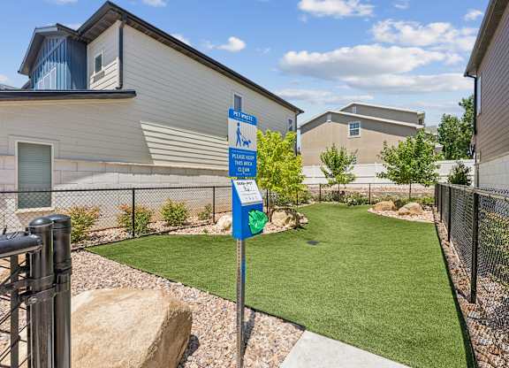 A backyard with a blue sign and a green lawn.