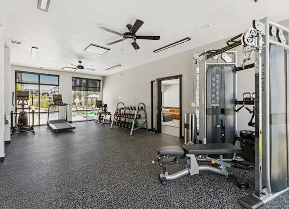 A spacious gym with a variety of equipment including a squat rack, bench, and weights.