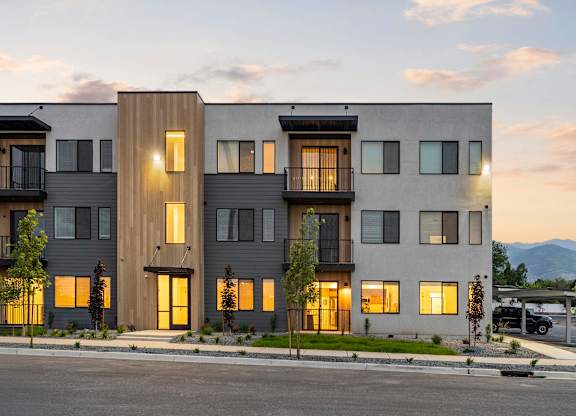 A modern apartment building with balconies and multiple windows is shown.