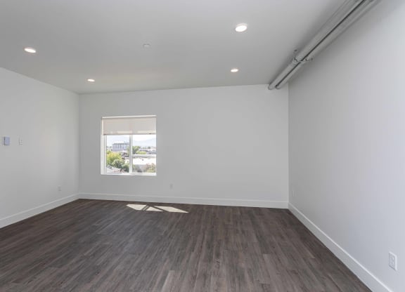 a living room with white walls and a window