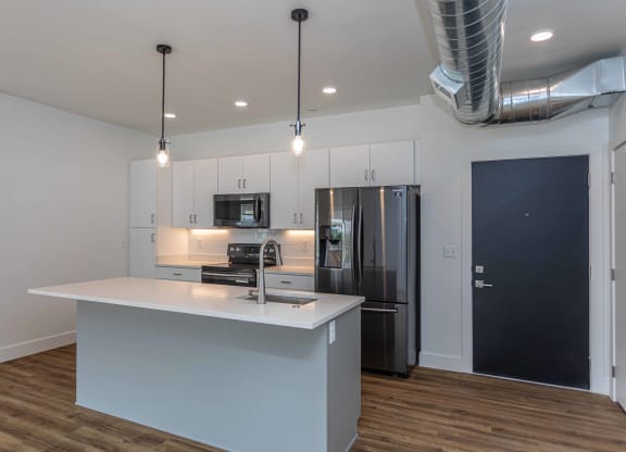 a kitchen with a large island and a stainless steel refrigerator