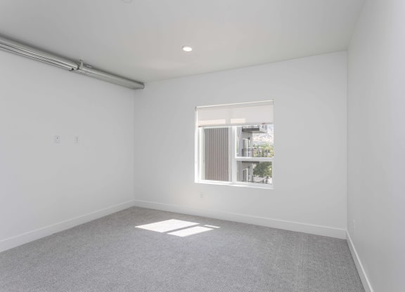 a living room with white walls and a window